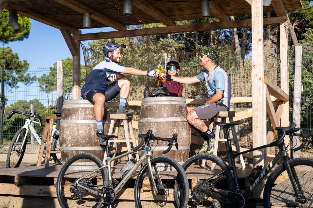 Ciclisti che brindano e si rilassano attorno a barili di legno dopo una pedalata