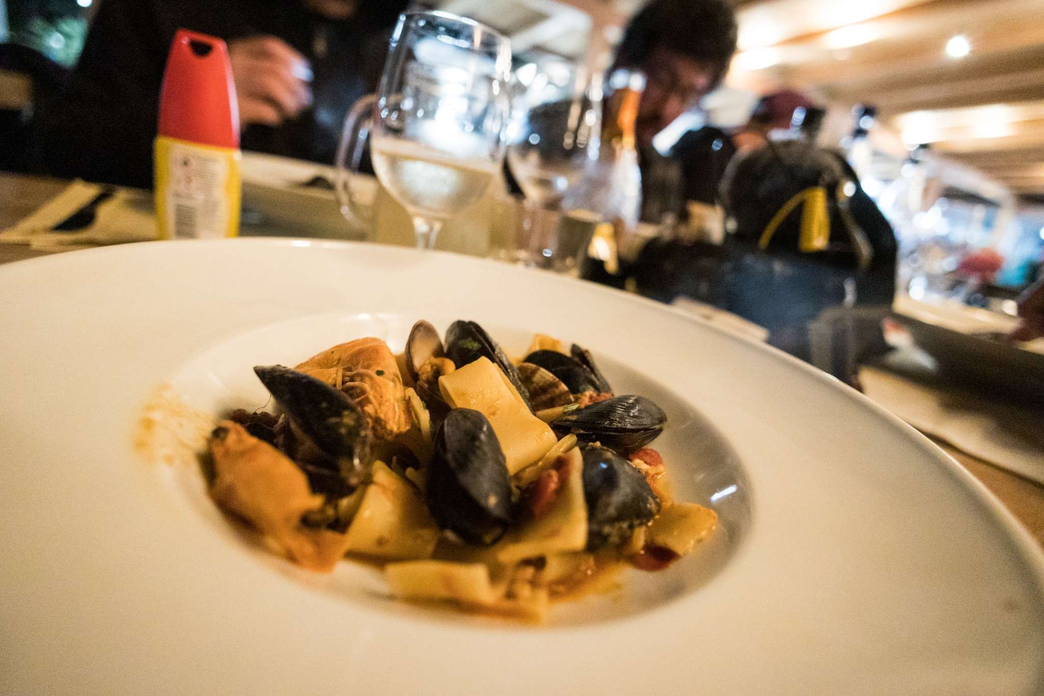 Piatto di paccheri ai frutti di mare con cozze e vino bianco in ristorante italiano